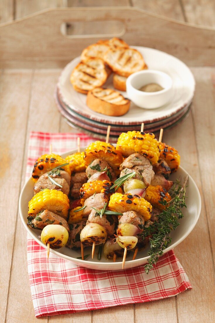 Barbecued skewers of loin pork, sweetcorn and shallots
