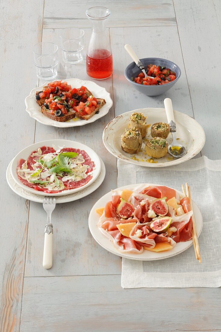 Vier verschiedene italienische Vorspeisen auf Tellern