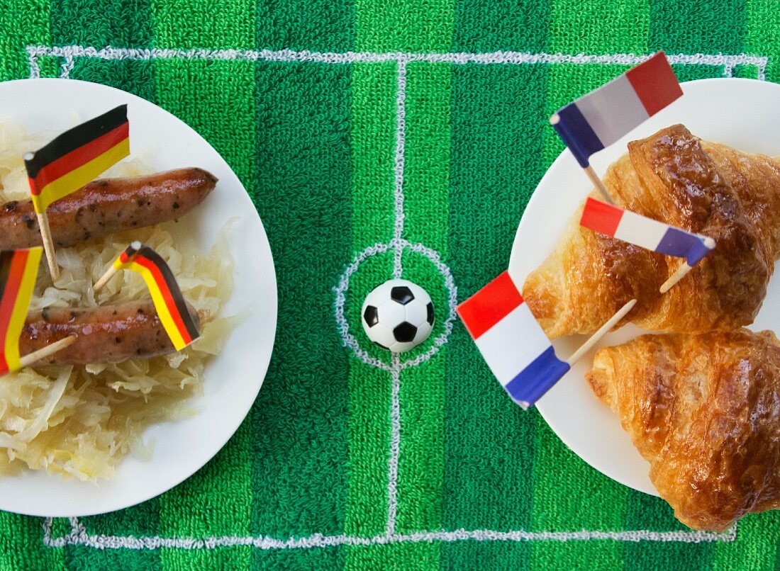 Sausages with cabbage (Germany) and croissants (France) with football-themed decoration