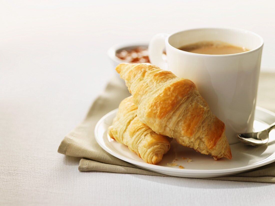 Two mini croissants and a cup of coffee