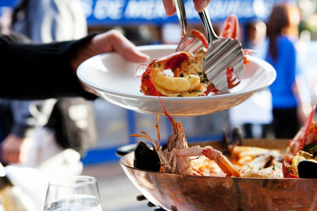 Serving Lobster From a Wooden Bowl with Tongs at an Outdoor Restaurant in the South of France