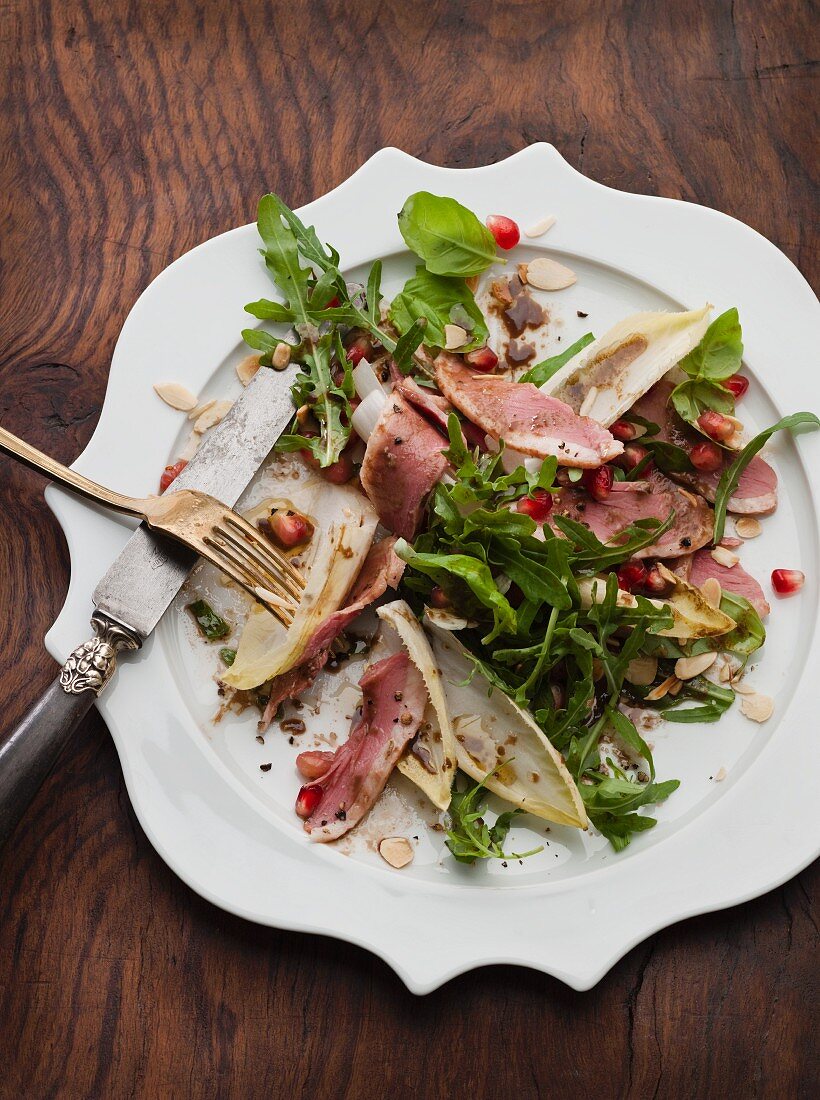Rocket salad with smoked duck breast, chicory and pomegranate vinaigrette