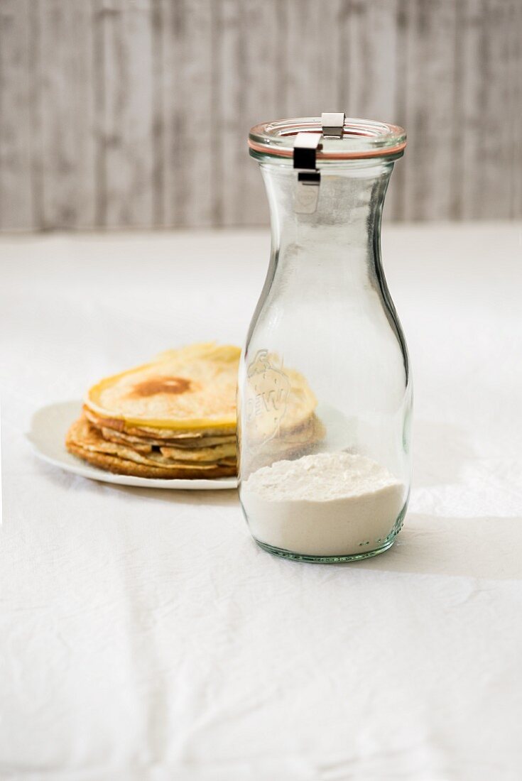 Backmischung für Pfannkuchen in einem Glas und fertige Pfannkuchen