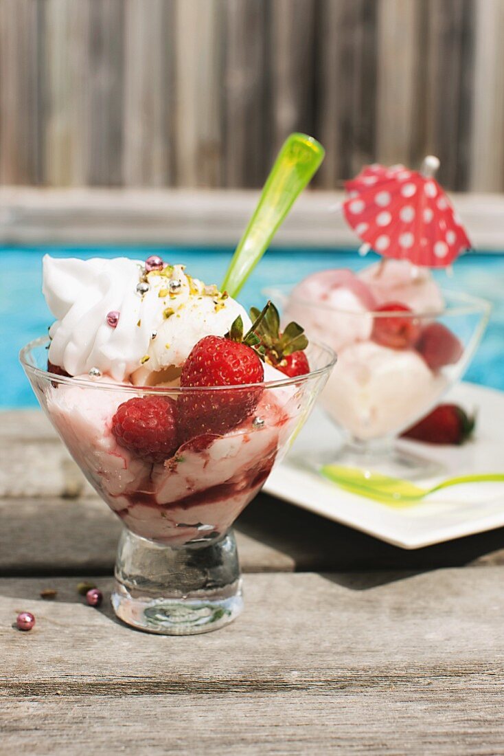 An ice cream sundae with summer berries by the pool