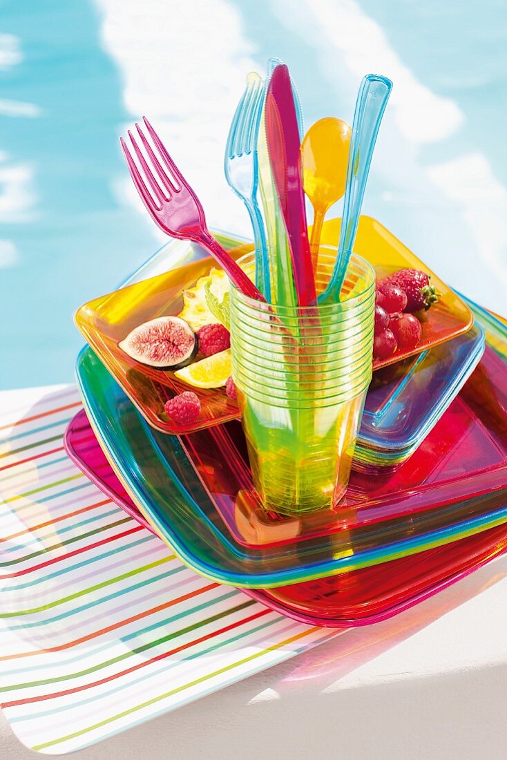 Plastic tableware and fruit by the swimming pool