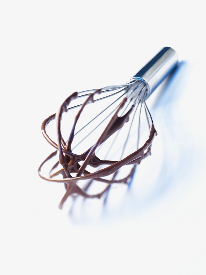 An egg whisk with remains of chocolate