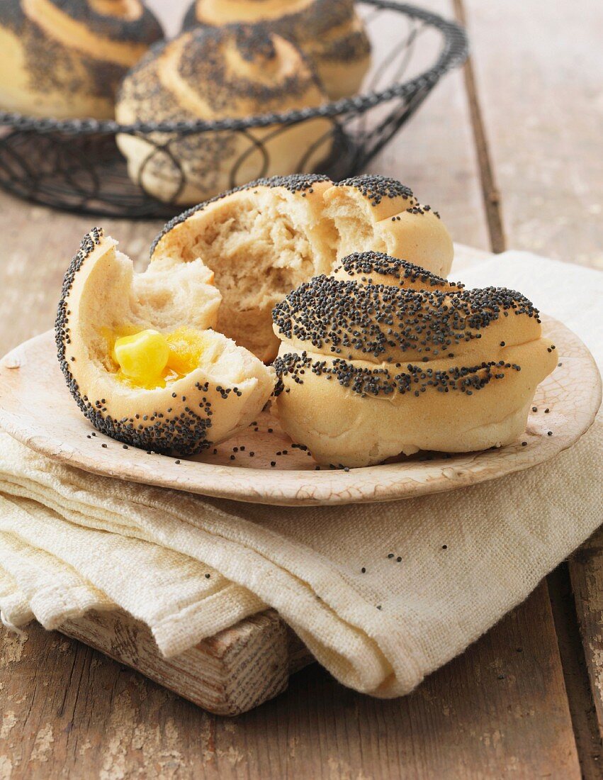 Poppy seed rolls with butter on cream linen napkin