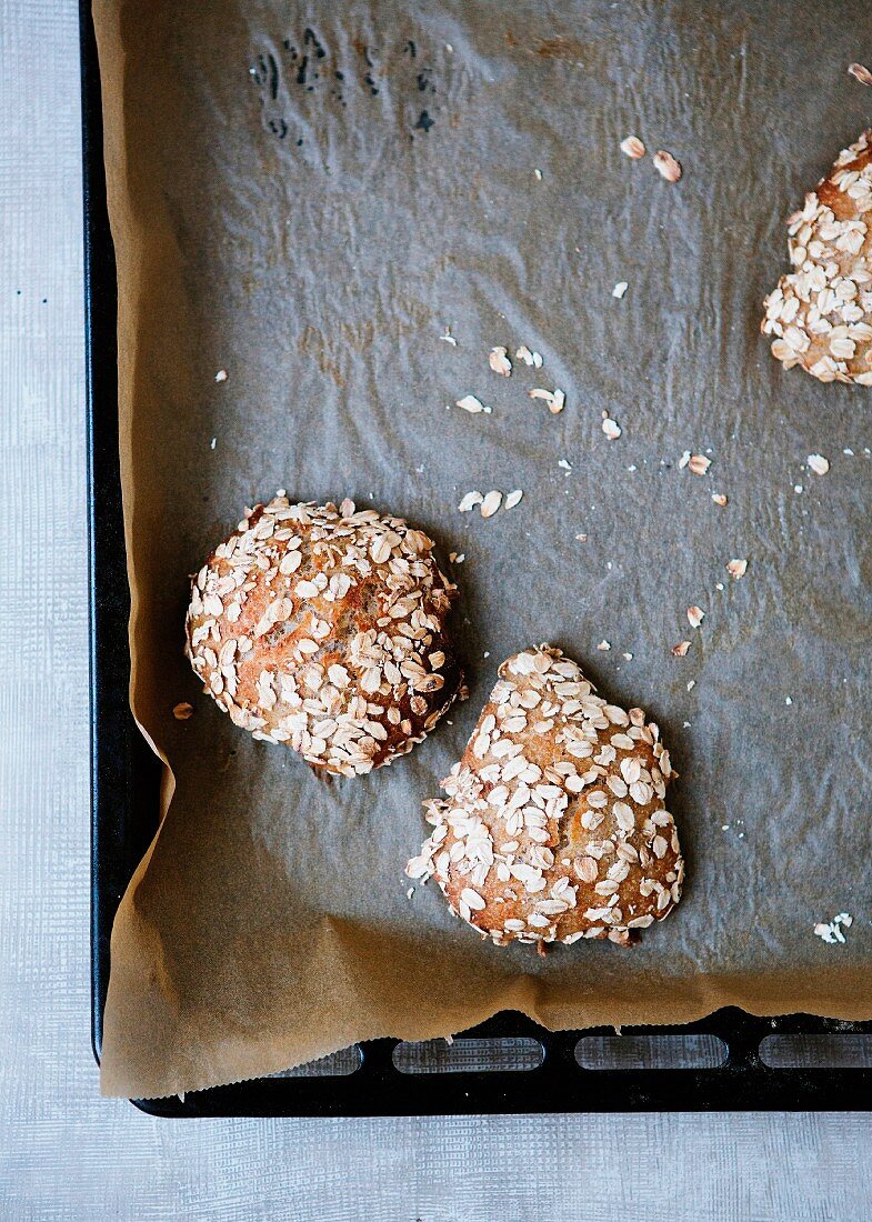 Drei Haferflockenbrötchen auf Backblech