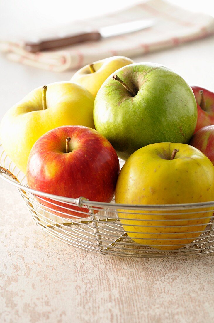 Verschiedene Äpfel in Drahtkorb