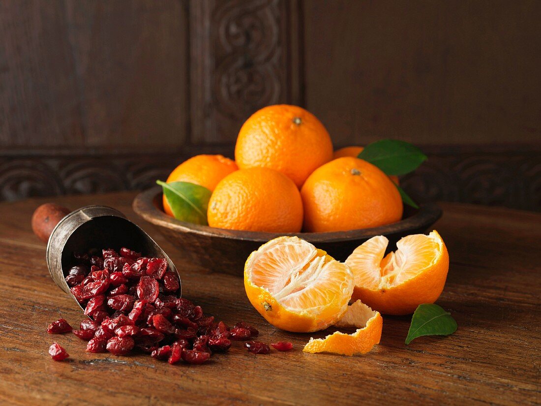 Stillleben mit frischen Clementinen und getrockneten Cranberries