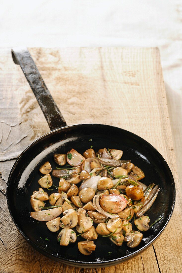 Gebratene Pilze mit Kräutern in der Pfanne