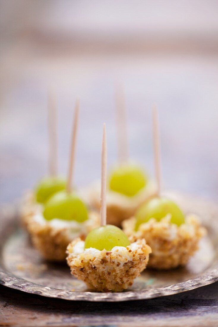 Grapes with cream cheese and nuts on cocktail sticks