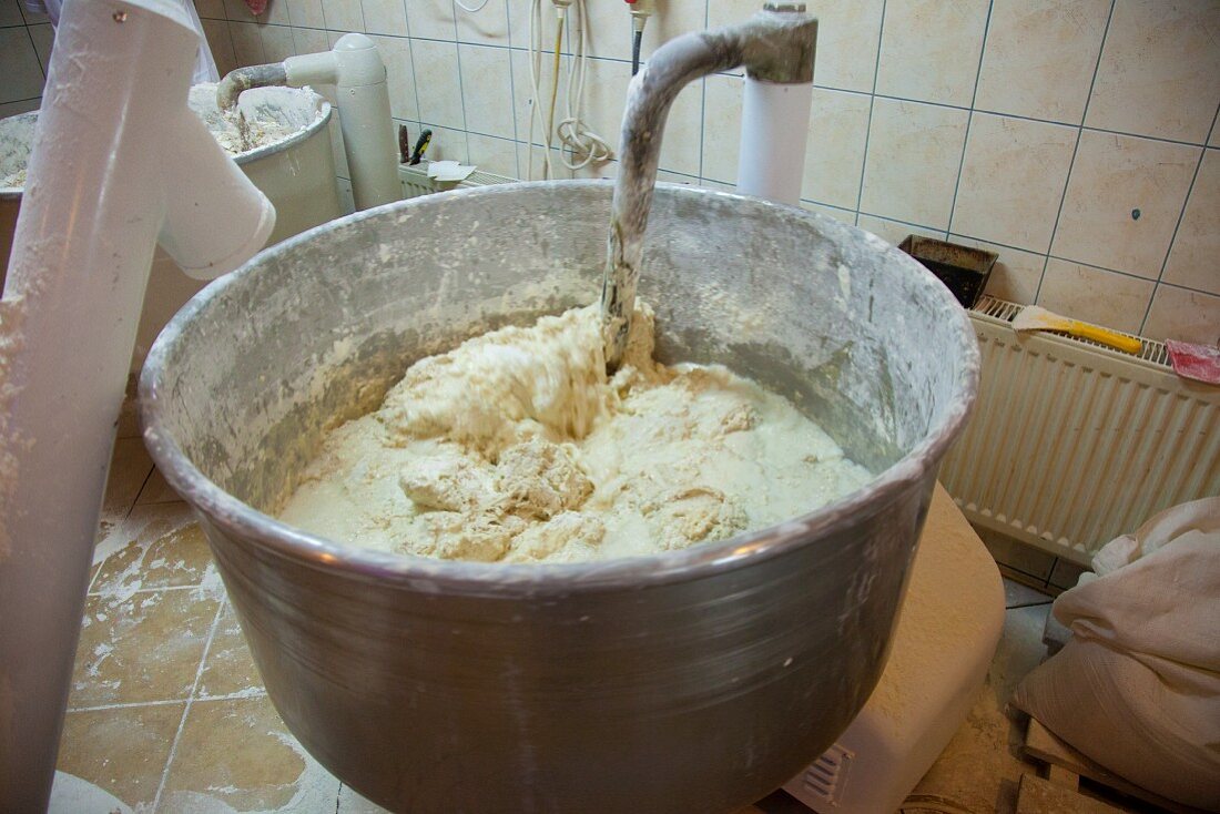 A machine kneading bread dough at a bakery