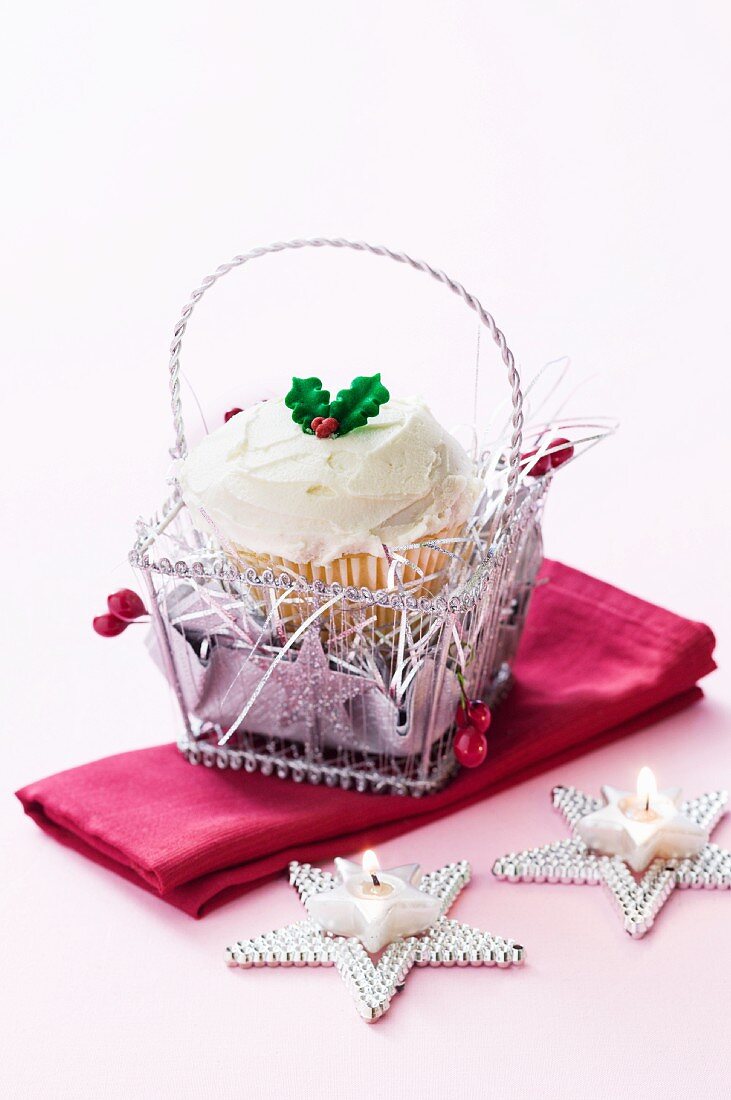 Weihnachtlicher Cupcake in Silberkörbchen und sternförmige Teelichter