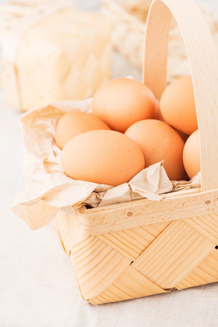 Fresh brown eggs in a woodchip basket