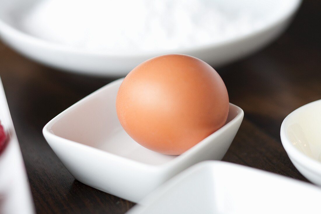 A brown egg in a small dish