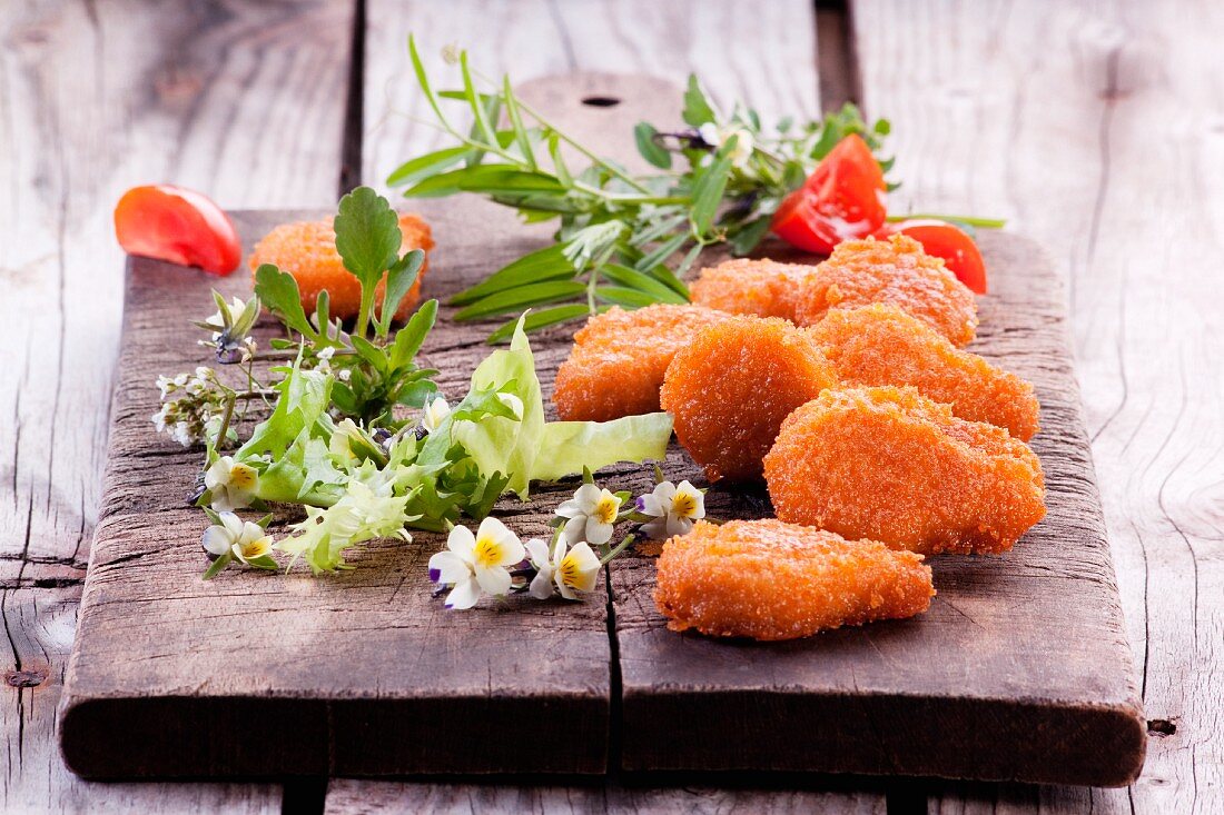 Chicken nuggets with salad leaves and edible flowers