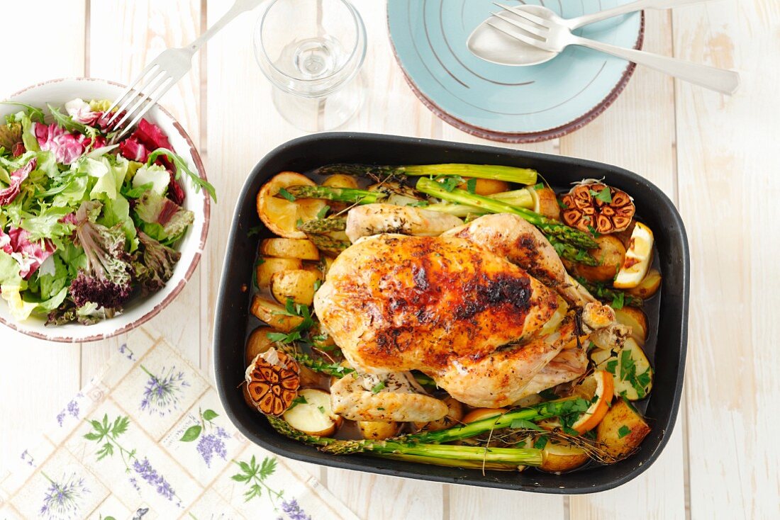 Roast chicken with garlic, asparagus, potatoes and apples
