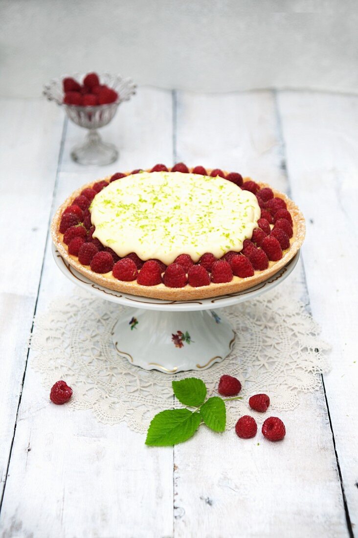 Raspberry tart with lime mousse on a cake stand