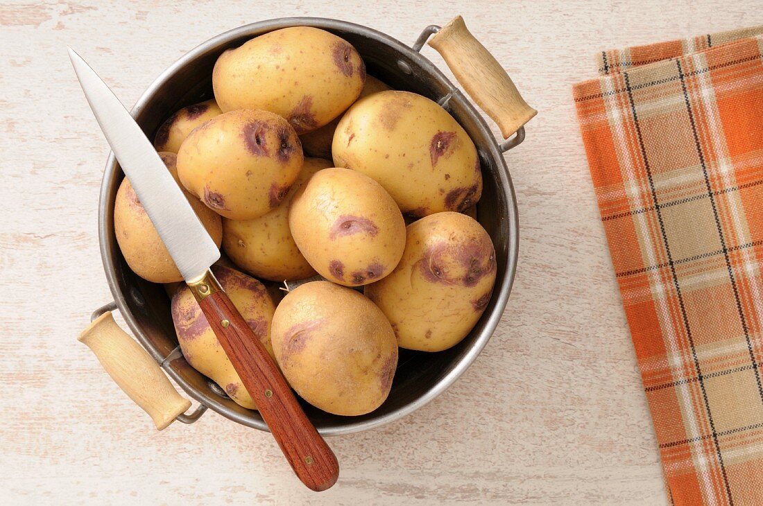 Kartoffeln im Küchensieb mit Messer