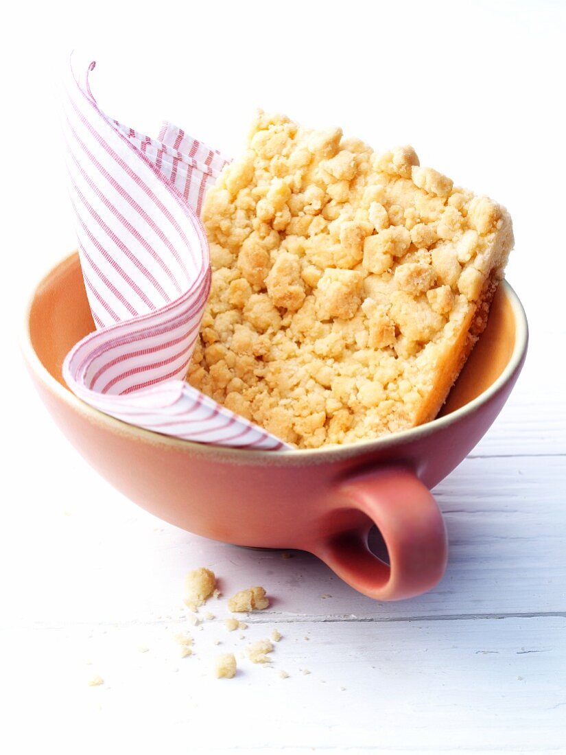A piece of crumble-topped cake in a cup