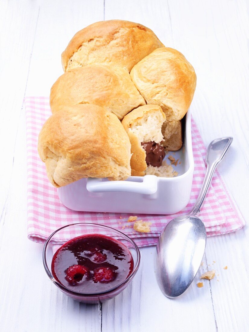 Buchteln (baked, sweet yeast dumplings) with nougat filling and raspberry sauce