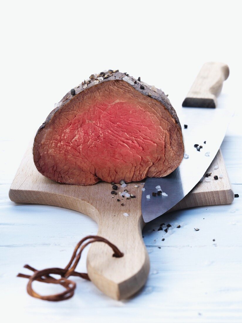 Fillet of beef with salt and black pepper on a chopping board