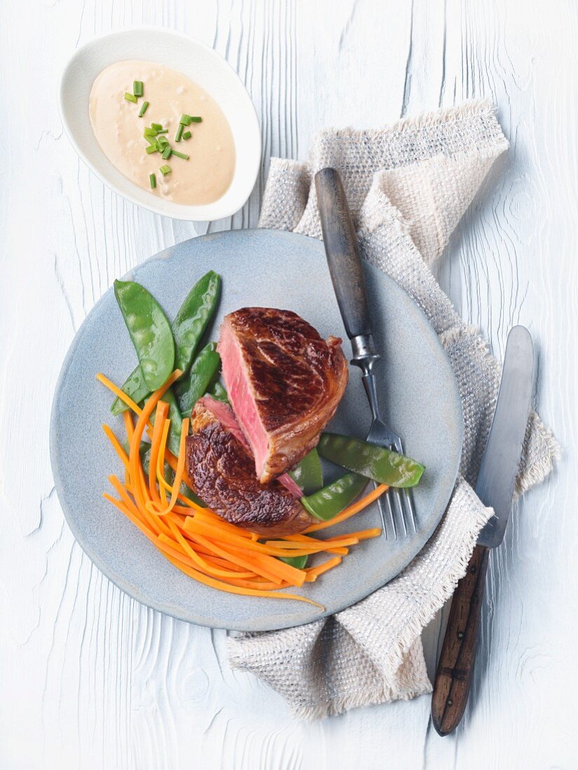 Veal steak with brandy sauce and spring vegetables