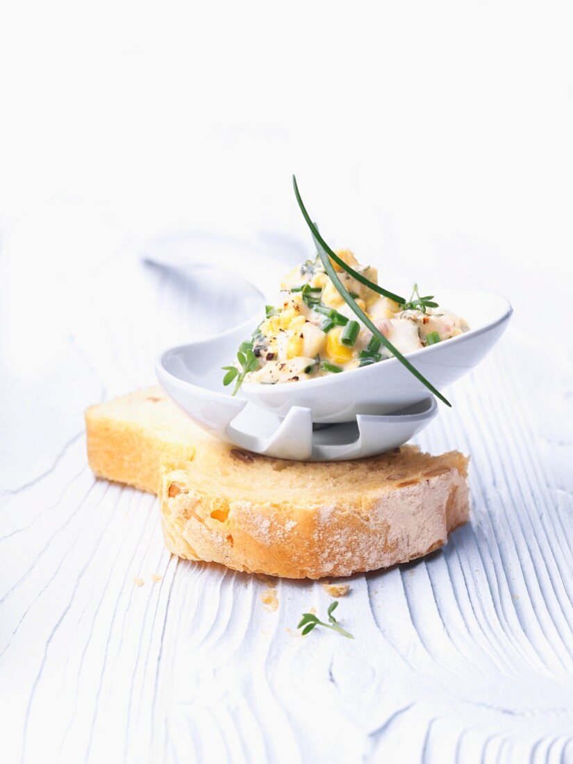 Egg mayonnaise in a dish on a slice of white bread