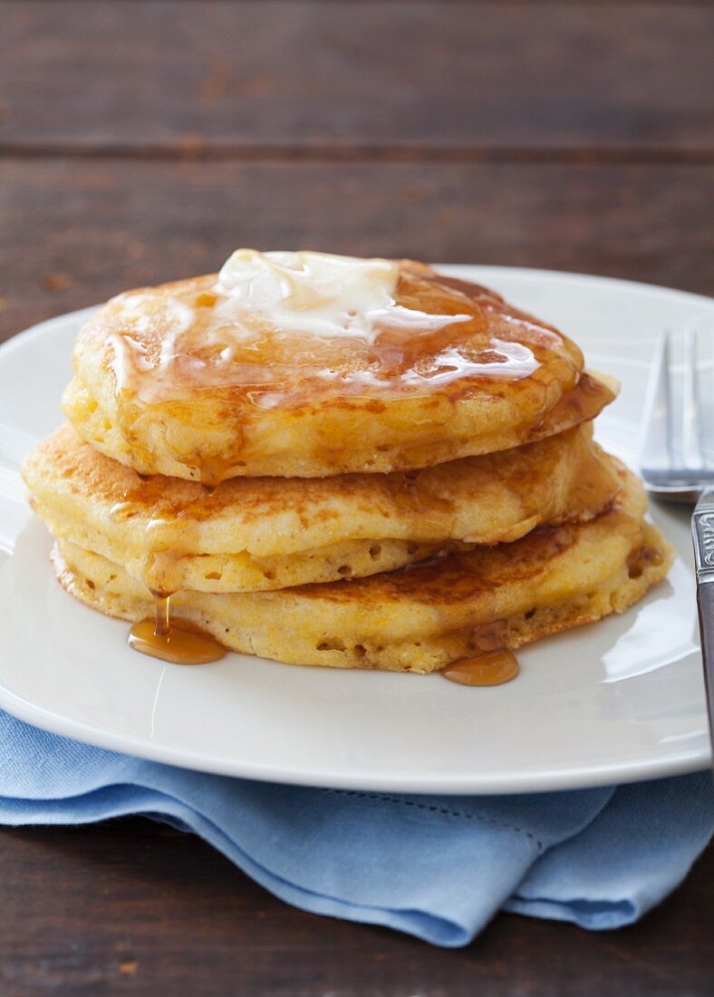 Gestapelte Maismehl-Pancakes mit Butter und Ahornsirup