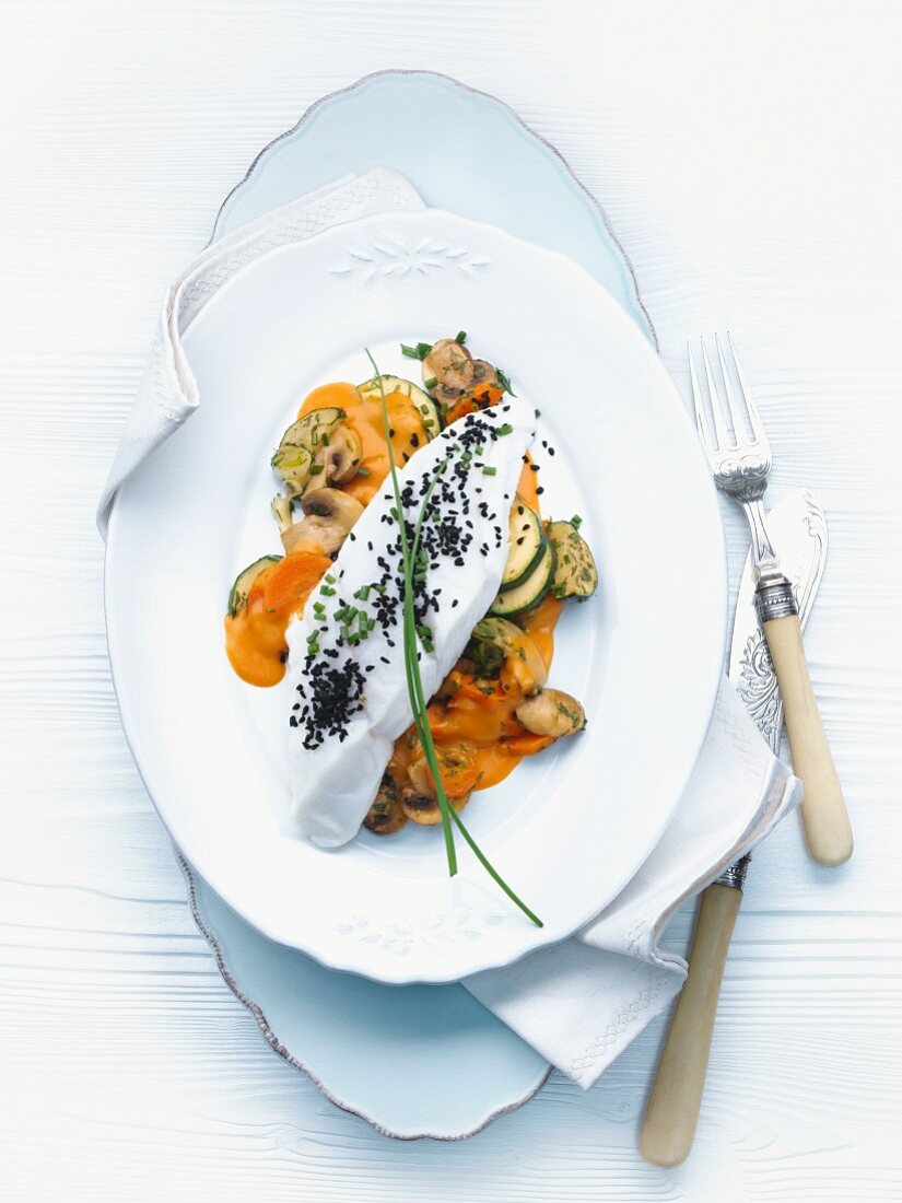 Catfish fillet with lobster butter on a bed of vegetables