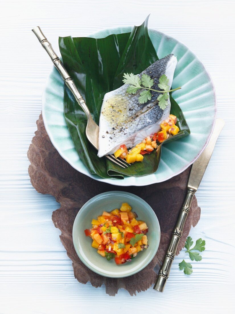 Wolfsbarschfilet im Bananenblatt mit Mango-Papaya-Salsa