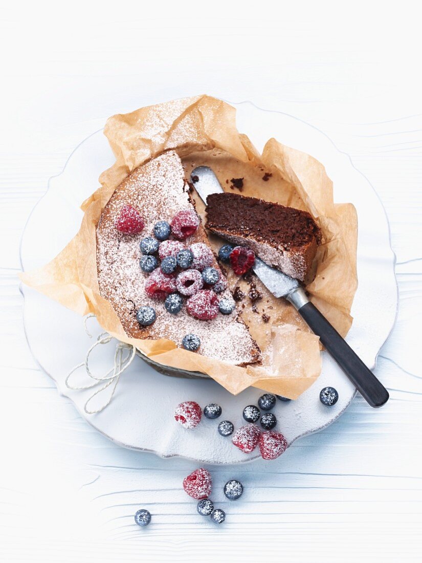 Chocolate and nut cake with berries and icing sugar