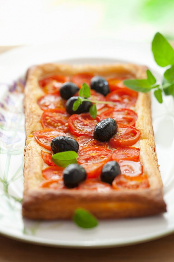 Puff pastry tart with cherry tomatoes, olives and oregano