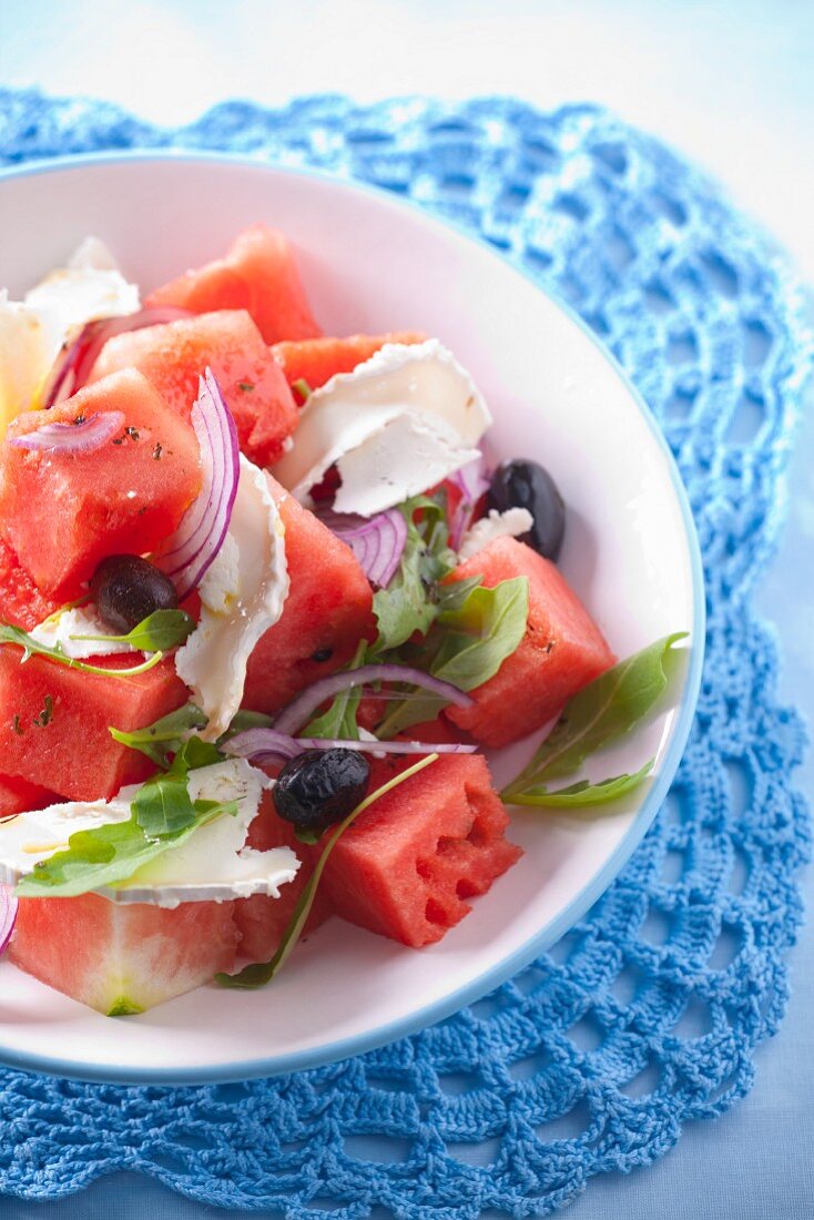 Wassermelonensalat mit Ziegenkäse, roten Zwiebeln, Oliven und Rucola