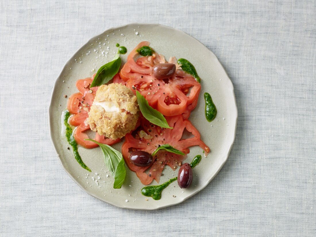 Baked mozzarella with tomato salad, olives and basil