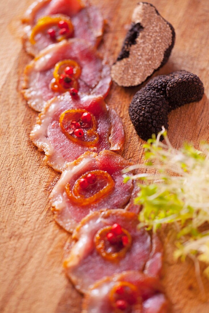 Venison Carpaccio marinated with truffles and garnished with caramelized onion