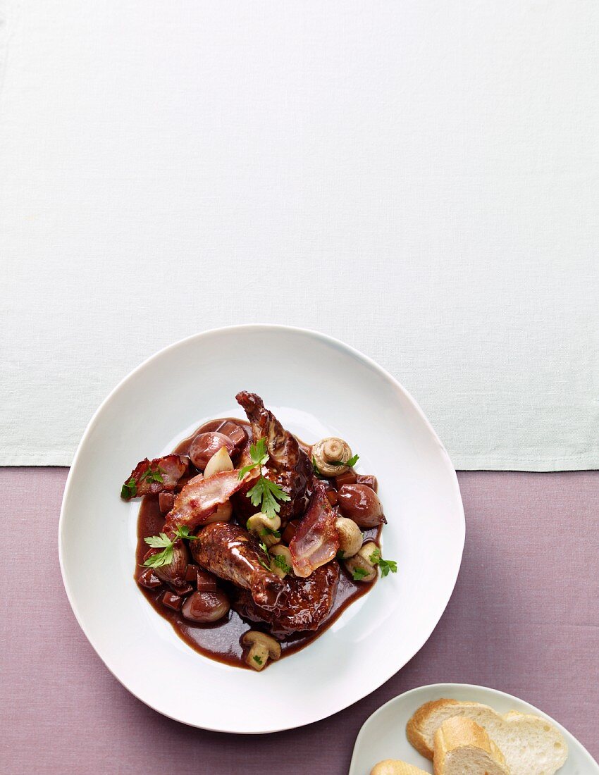 Coq au vin with mushrooms and baguette