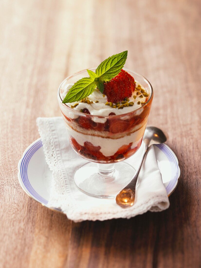 Parfait with a sponge cake, strawberries and pistachios