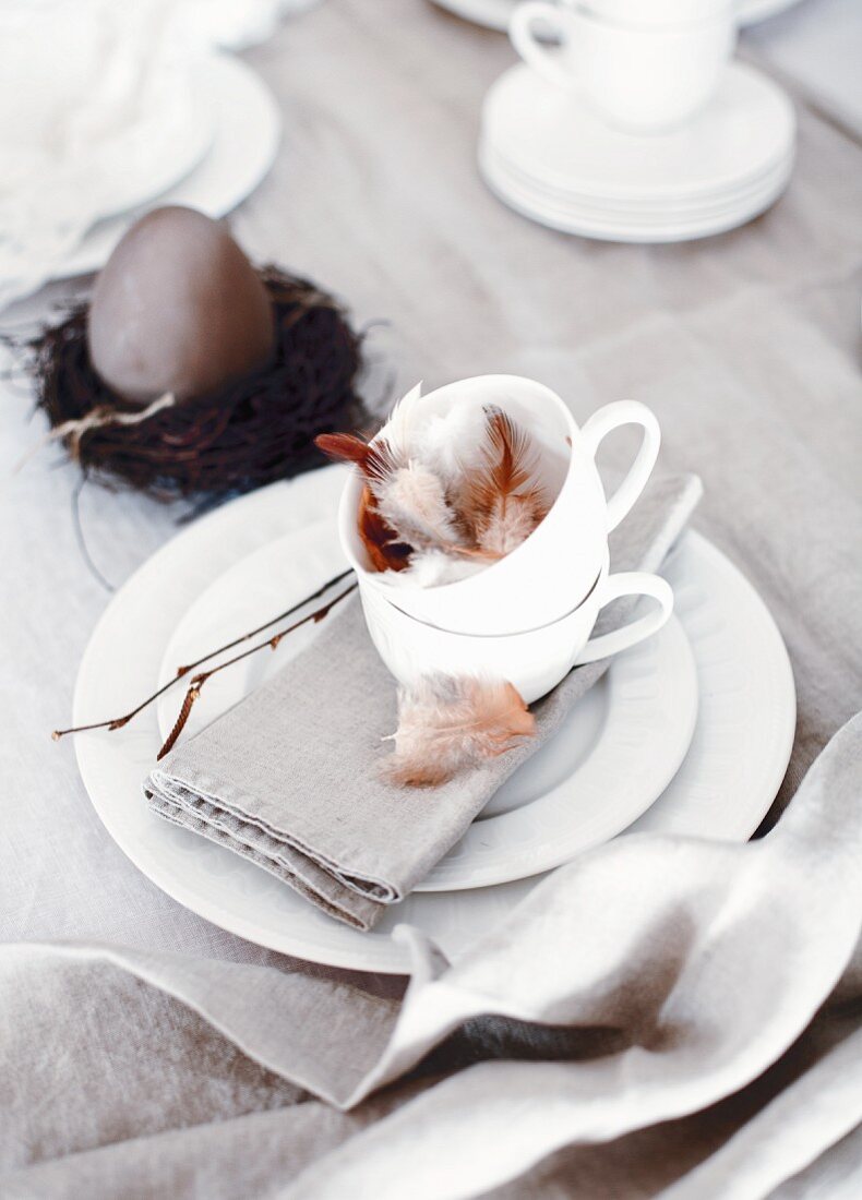 Ostergedeck mit Vogelfedern in Tasse