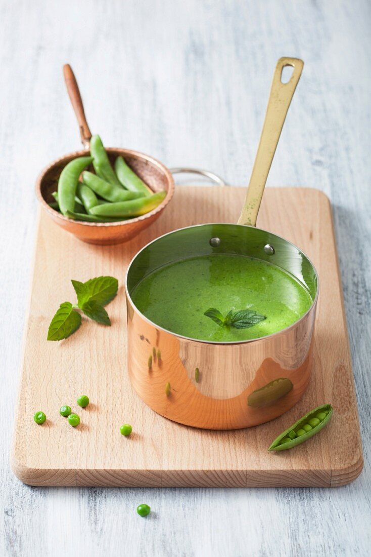 Cream of pea soup with mint in a copper saucepan