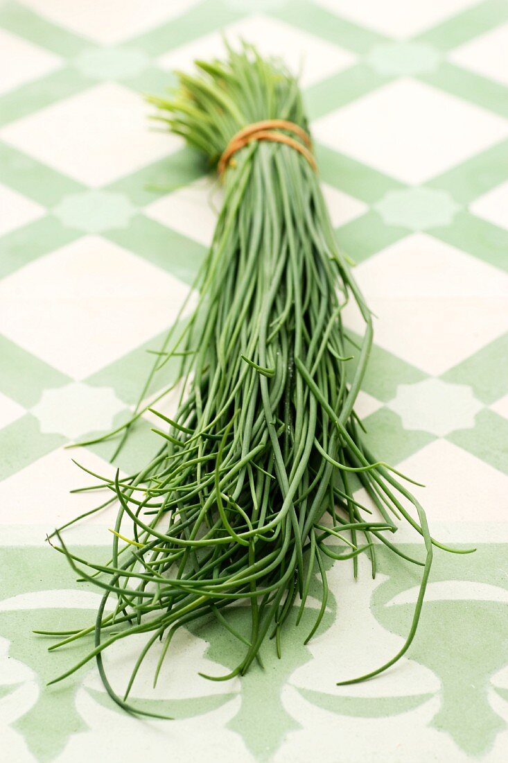 A bunch of chives on a tiled surface