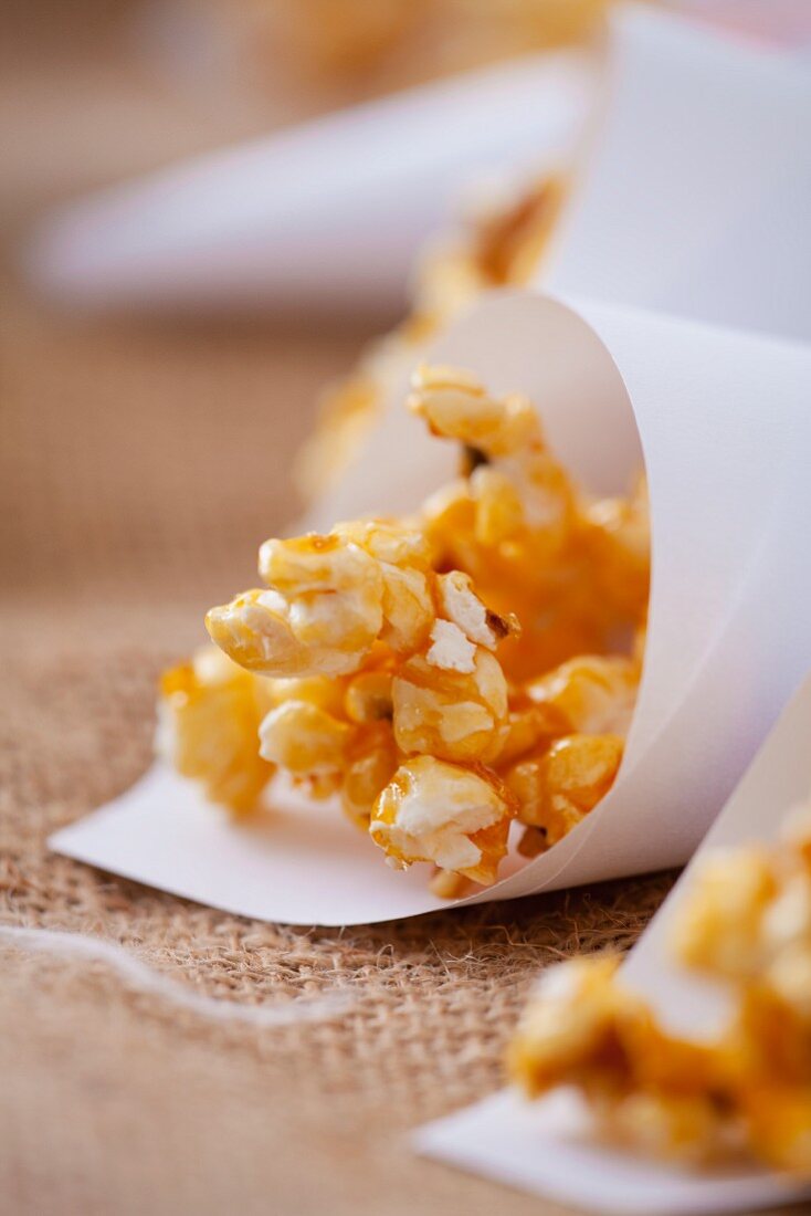 Caramelised popcorn in paper cones (close-up)