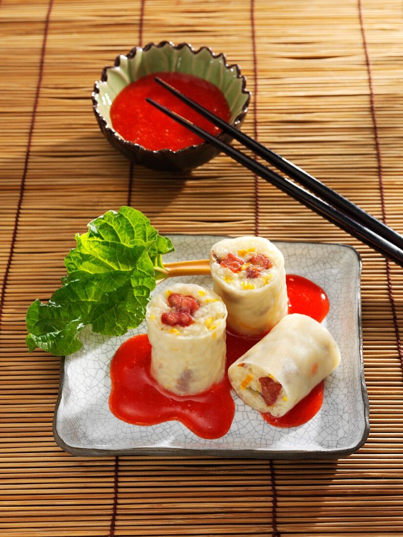 Sweet pudding rice rolls with rhubarb in strawberry sauce