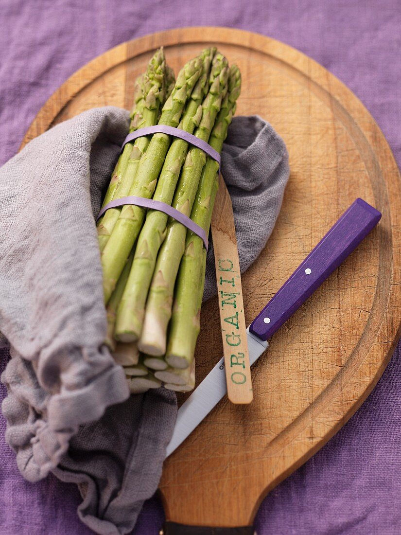 Green asparagus, bundled, on a chopping board