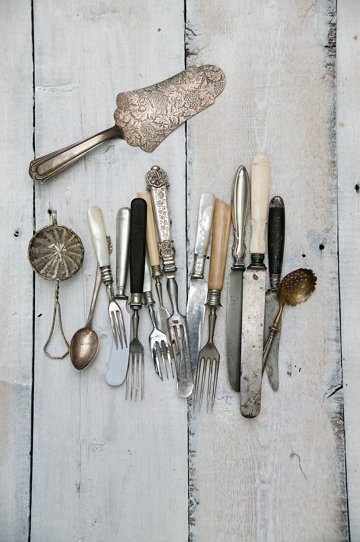 Antique cutlery and utensils on a wooden surface