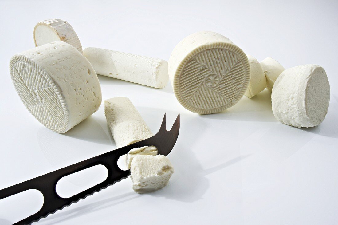 Assorted types of fresh goat's cheese with a cheese knife