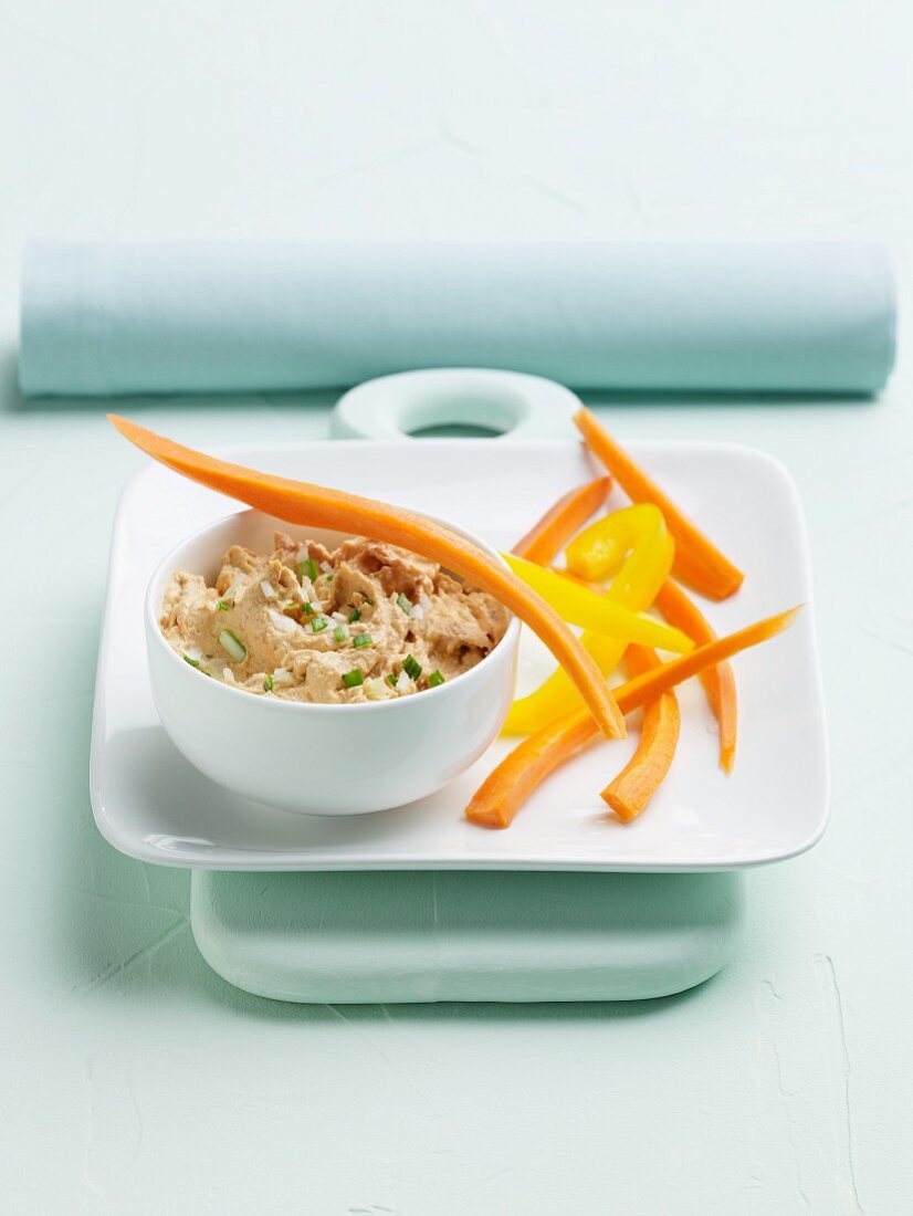 A Bowl of Tuscan White Bean Dip with Carrot and Pepper Strips