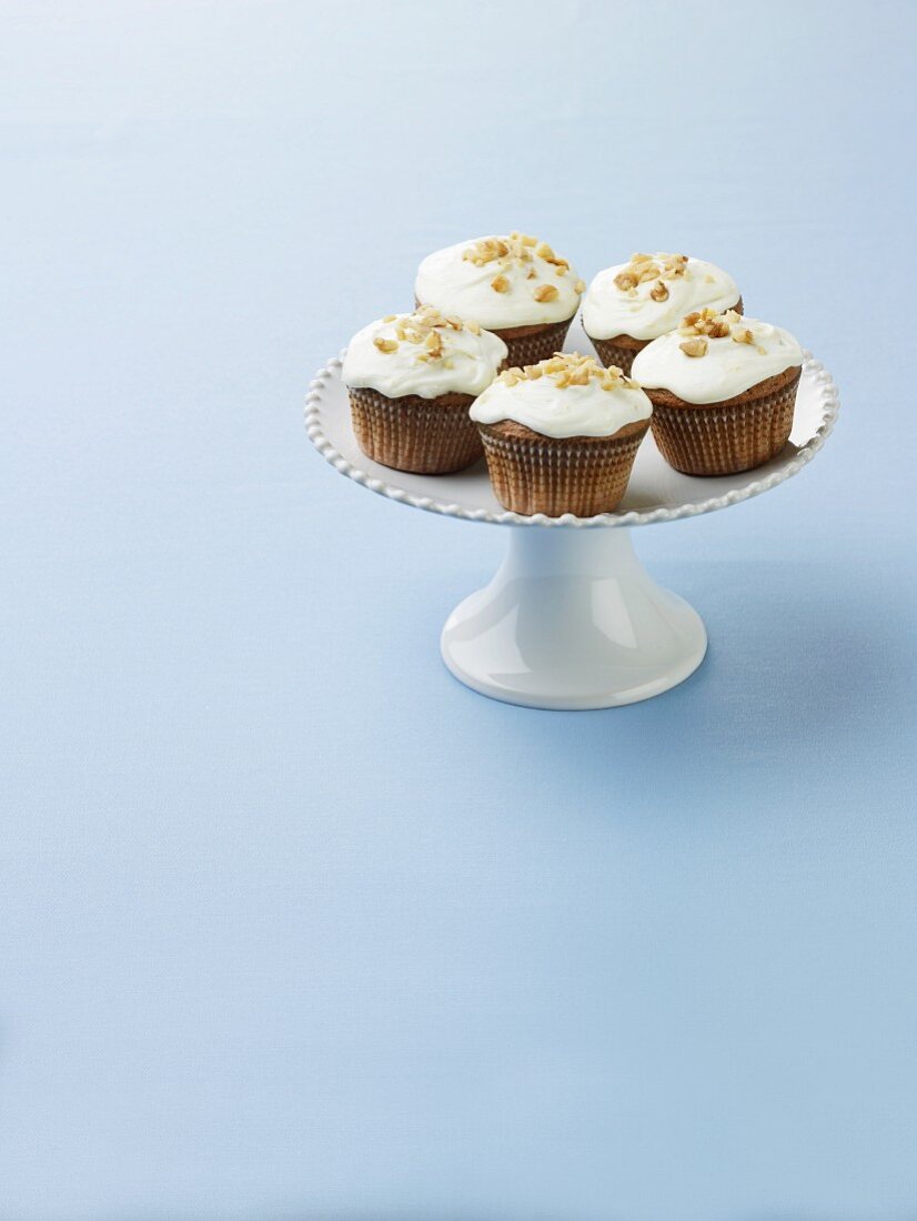 Frosted Cupcakes with Nut Topping on a Pedestal Dish