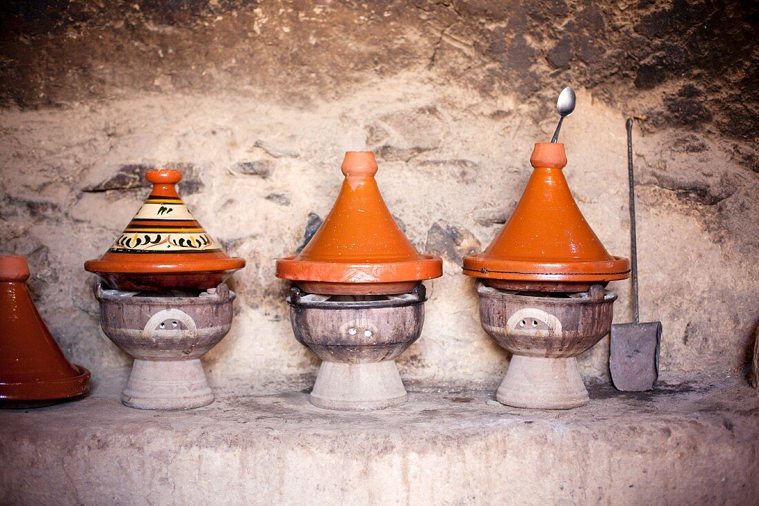 Several tagine pots on small barbecue ovens